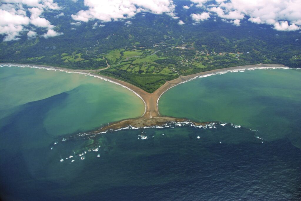 Stunning aerial drone photograph of the famous Whale's Tail sandbar formation in Marino Ballena National Park during low tide, surrounded by turquoise ocean water.
